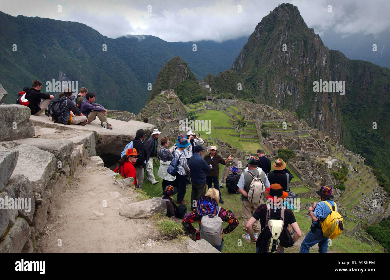 Un guide parlant à un groupe de touristes en visite à Machu Picchu au Pérou Amérique du Sud Banque D'Images