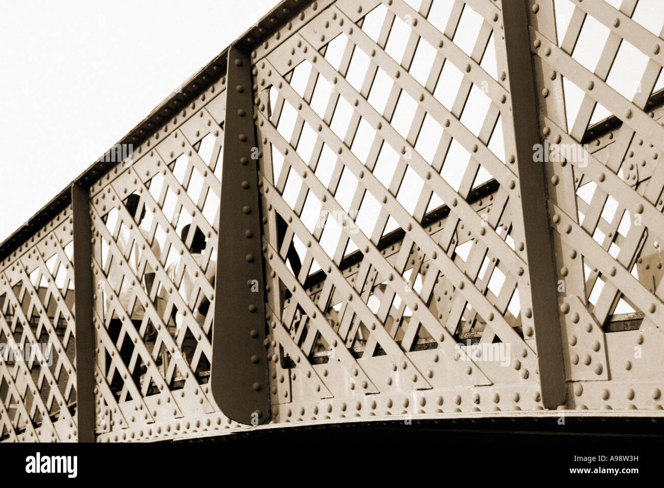 ABSTRACT BRIDGE créé à partir de détail du Groenland Dock passerelle, Rotherhithe. Image Sépia - deux enfants traversant sur la gauche. Banque D'Images