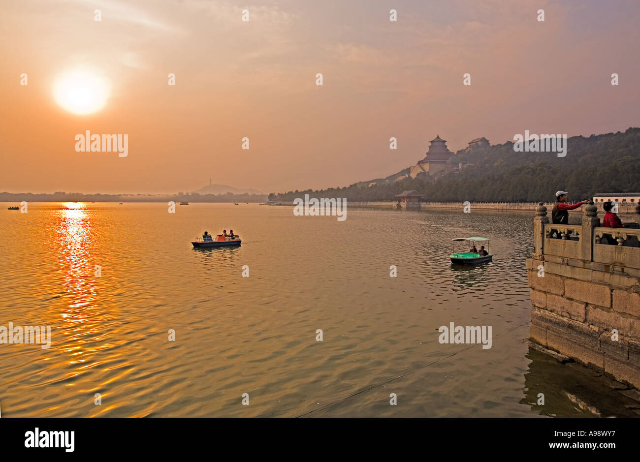 Chine Pékin les touristes des bateaux à aube au coucher du soleil sur le Lac de Kunming Banque D'Images