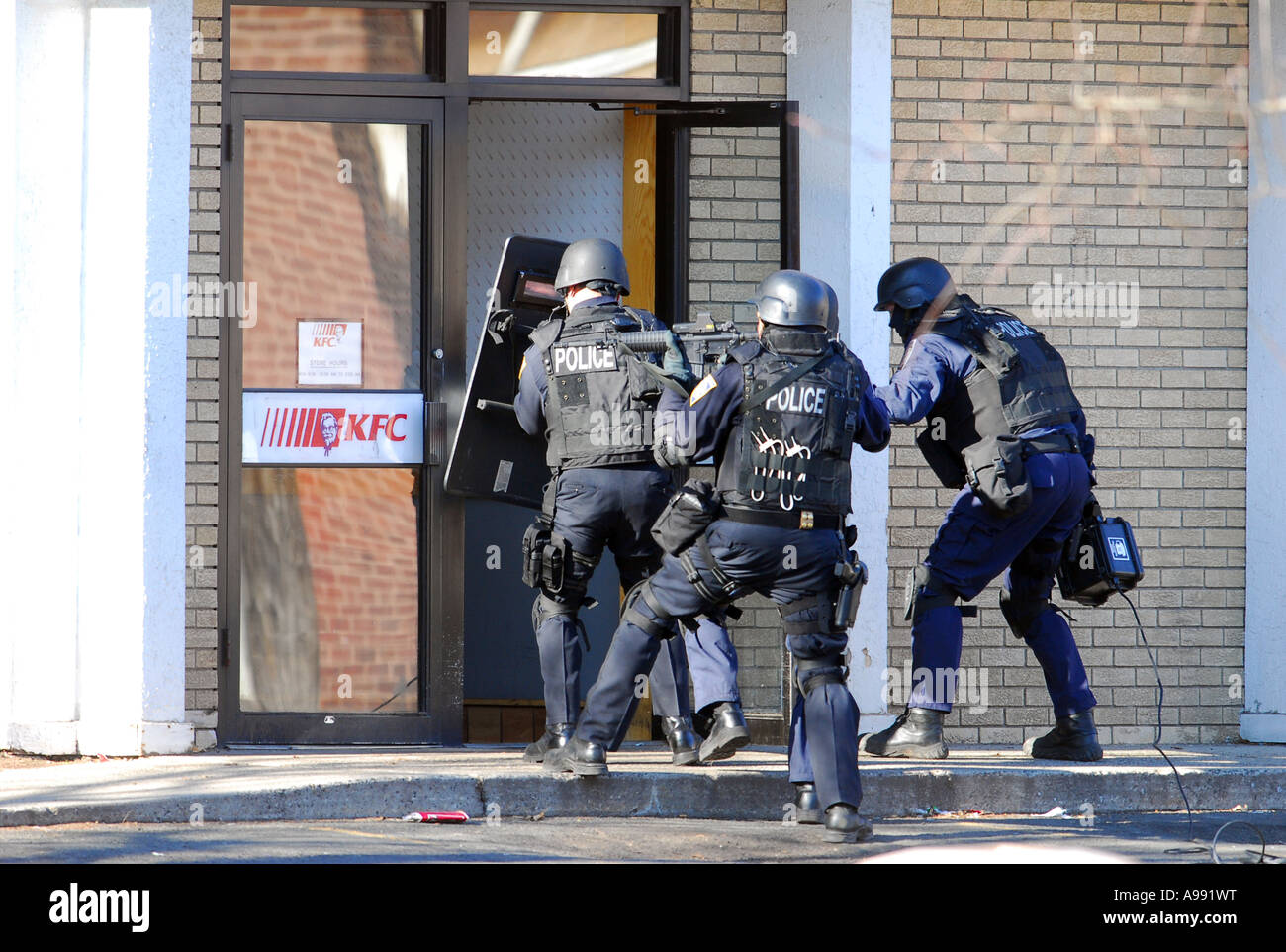 L'équipe Swat flics storm un restaurant à la recherche d'un homme avec un fusil qui a été perforé à l'intérieur Banque D'Images