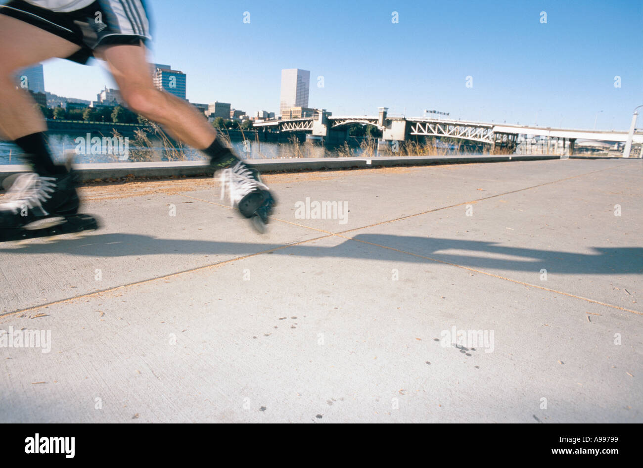 Troubles de jambes d'un patineur en ligne alors qu'il accélère le long d'un chemin de randonnée à l'échelle d'une ville Banque D'Images