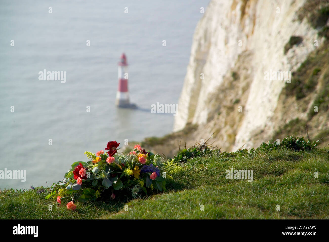 Regarder sur Beachy Head Lighthouse depuis le haut de la falaise avec couronne memorial en premier plan Banque D'Images