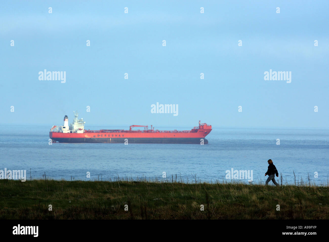 Personne à marcher le long du sentier côtier près de Stonehaven, London, UK, montrant un navire au loin dans la mer du Nord Banque D'Images