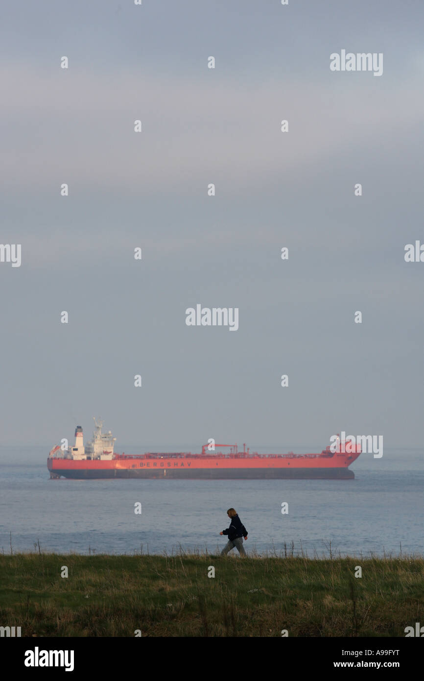 Personne à marcher le long du sentier côtier près de Stonehaven, London, UK, montrant un navire au loin dans la mer du Nord Banque D'Images