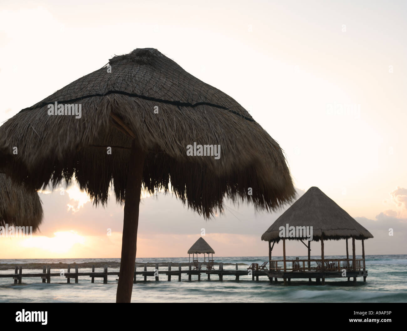 Le Mexique Péninsule du Yucatan Quintana Roo Cancun Riviera Maya pier avec palapa s'avance à l'eau de la plage au lever du soleil Banque D'Images
