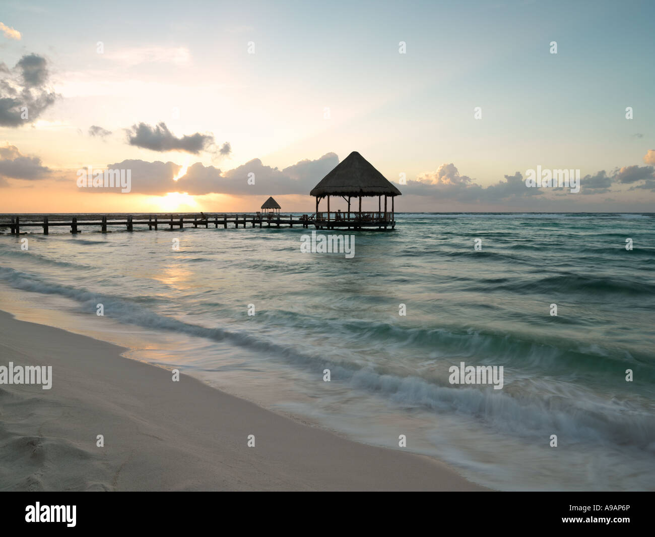 Le Mexique Péninsule du Yucatan Quintana Roo Cancun Riviera Maya pier avec palapa s'avance à l'eau de la plage au lever du soleil Banque D'Images