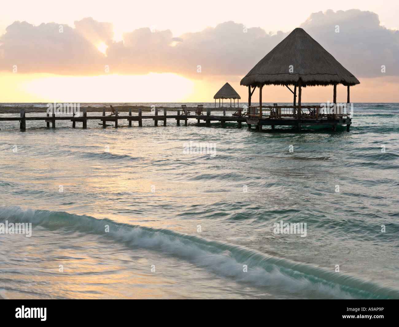 Le Mexique Péninsule du Yucatan Quintana Roo Cancun Riviera Maya pier avec palapa s'avance à l'eau de la plage au lever du soleil Banque D'Images