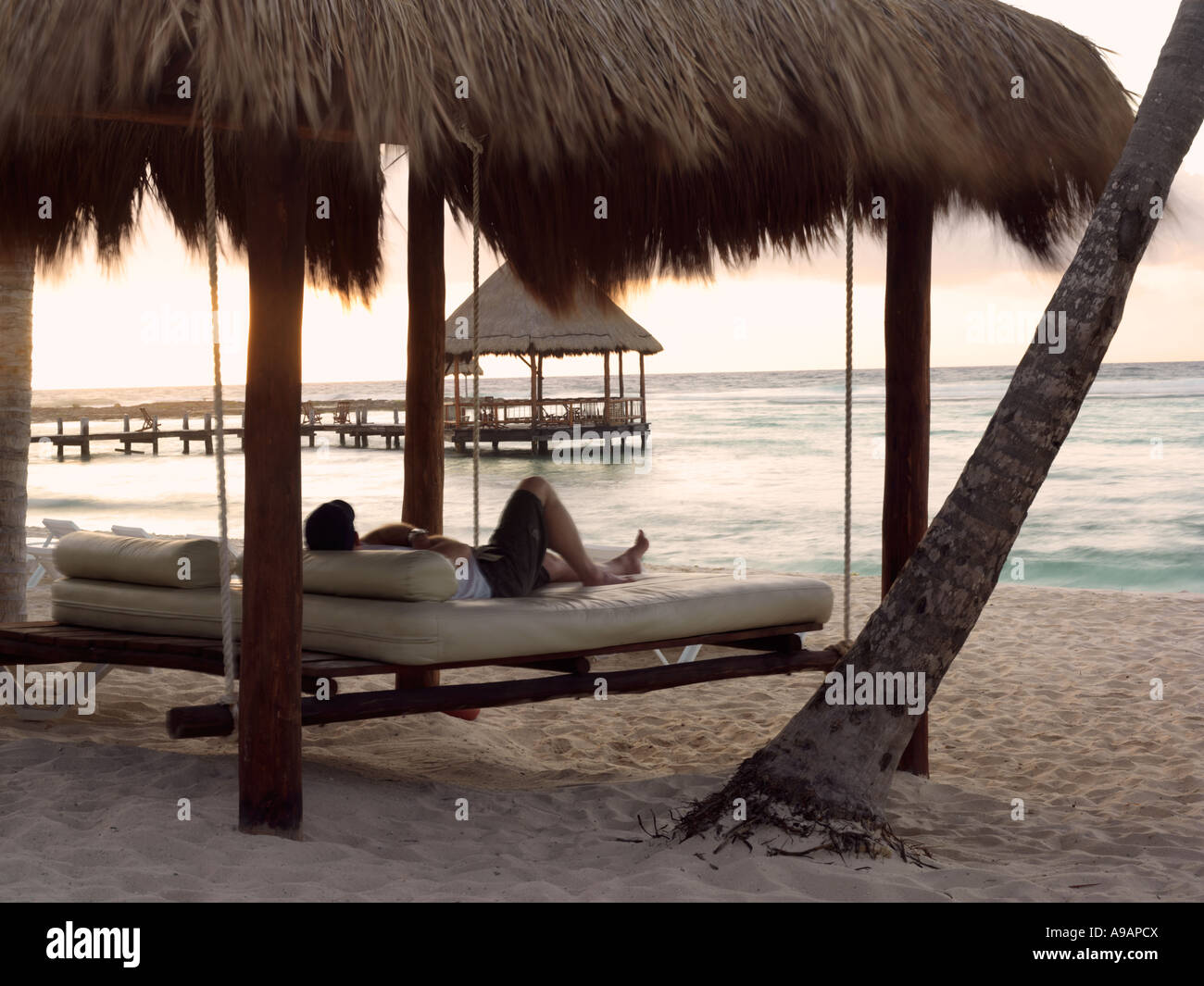 Le Mexique Péninsule du Yucatan Quintana Roo Cancun Riviera Maya l'homme portant sur la valse à regarder le lever du soleil palapa Banque D'Images