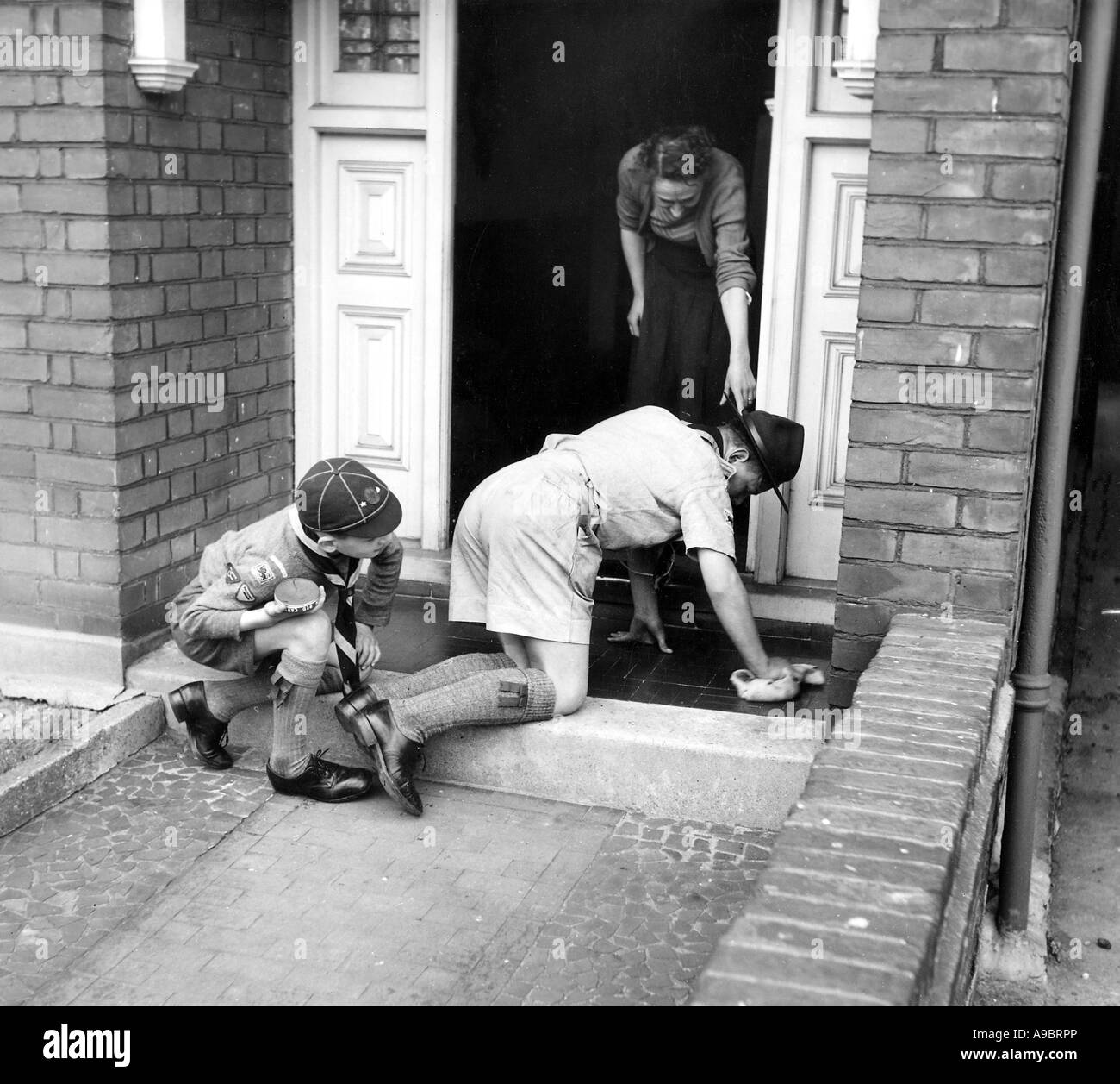 Londres et Cub Scout d'effectuer une tâche de travail un Bob sur 1950 Banque D'Images