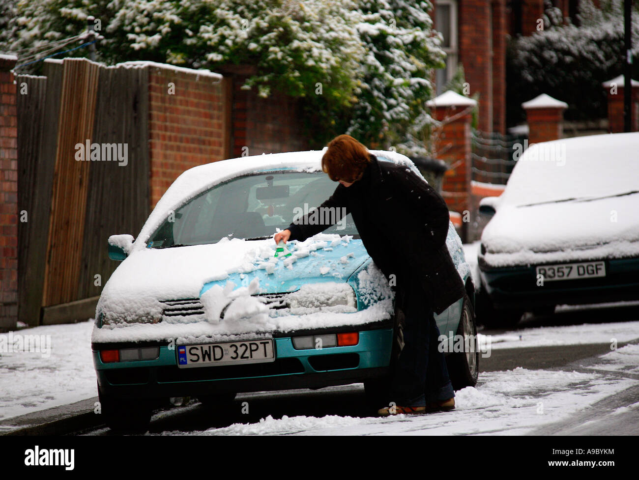 Nettoyage de la neige fraîche femme bonnet de voiture Banque D'Images