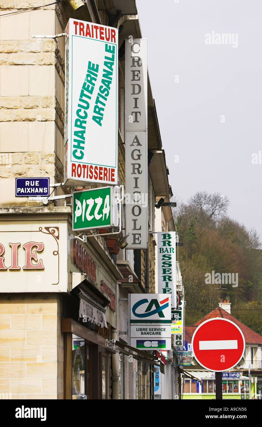 Ligne de magasin de détail au-dessus d'une signalisation rue dans un village français Banque D'Images