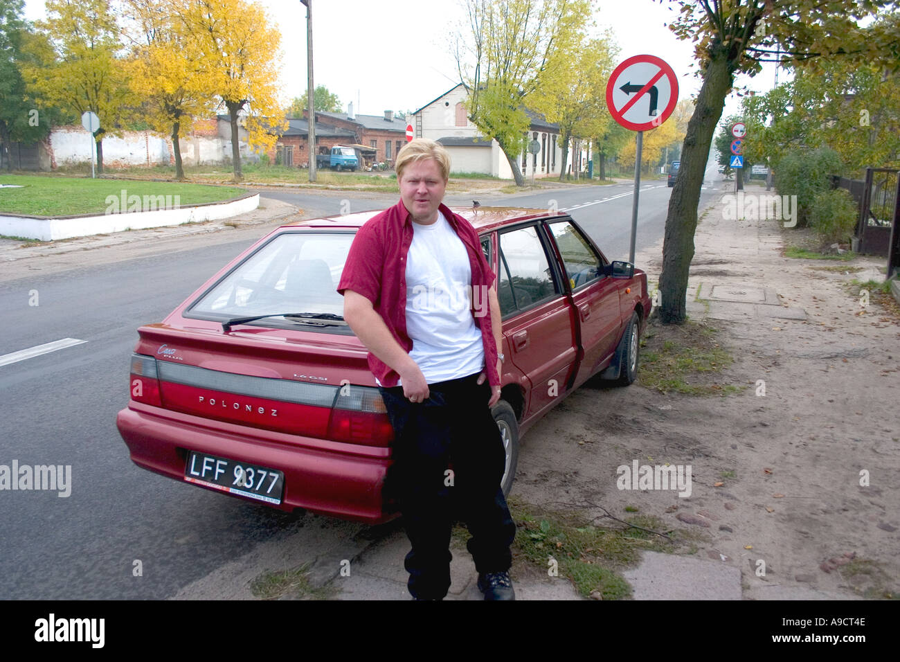 Polish suspectes homme debout par sa voiture rouge. L'autoroute 72 entre Lodz et Rawa Maz. Pologne Banque D'Images