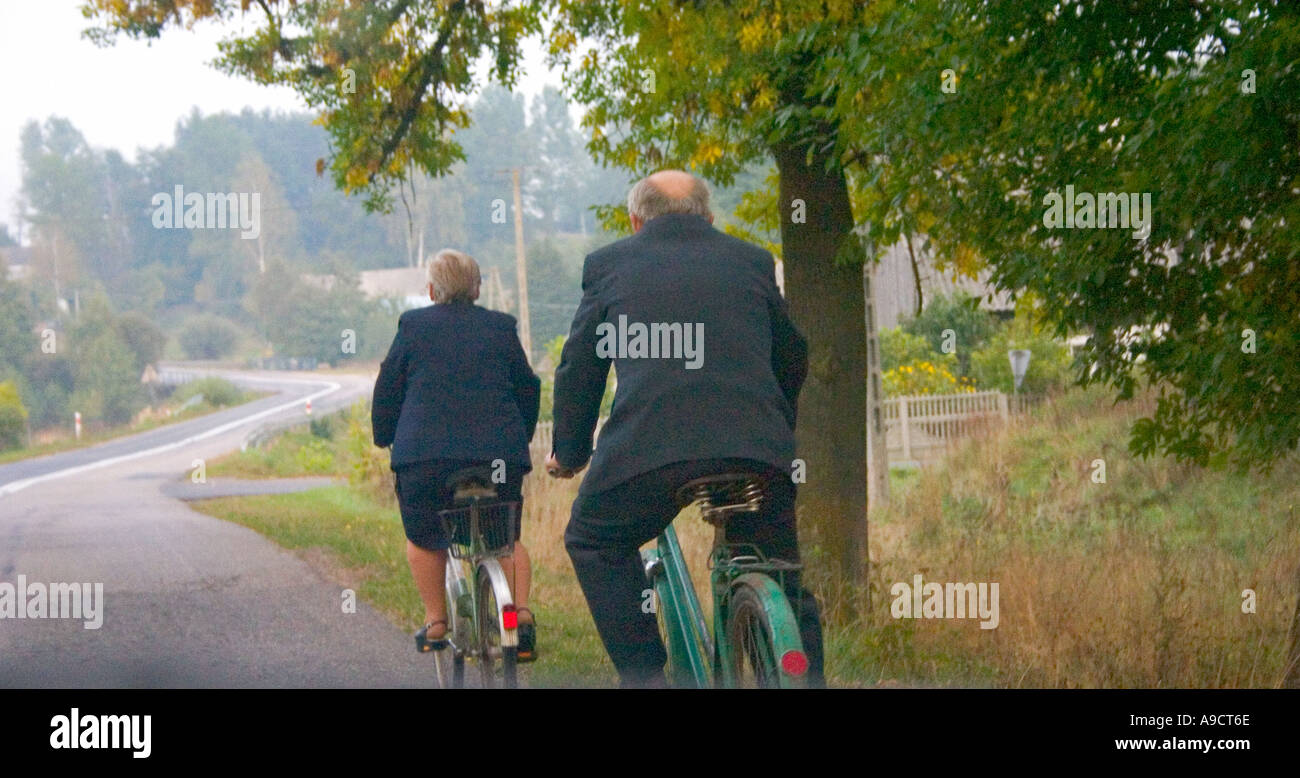 Vieux couple bien habillé la bicyclette le long de la route. L'autoroute 72 entre Lodz et Rawa Maz. Pologne Banque D'Images