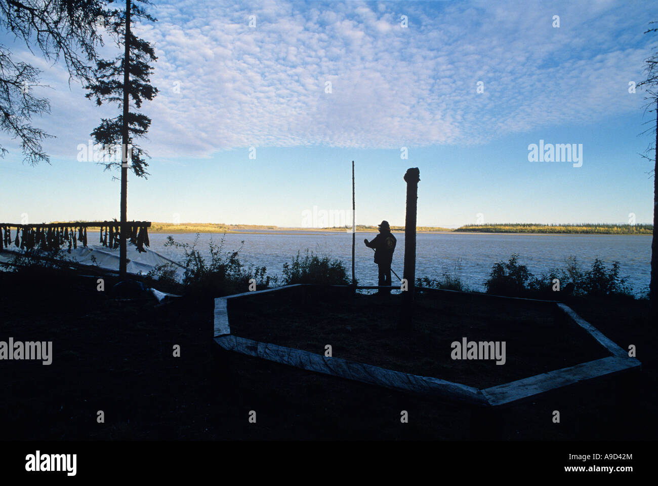 USA Alaska Indien Athabascan David John watches coucher de soleil sur la rivière Yukon, à fish camp près de Fort Yukon Banque D'Images
