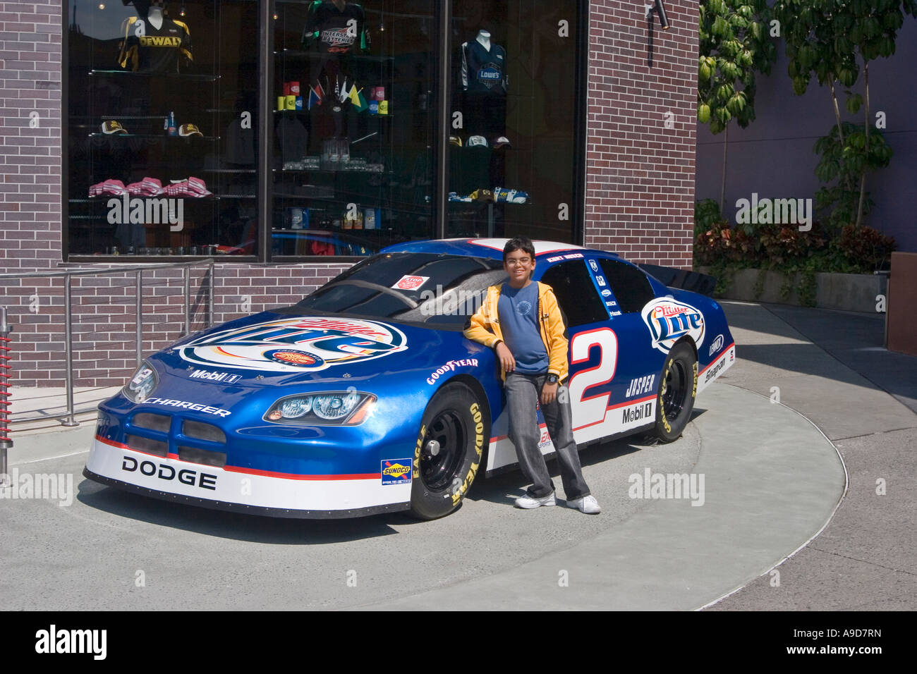 Un jeune garçon pose devant une voiture à Universal Studios, en Floride Banque D'Images