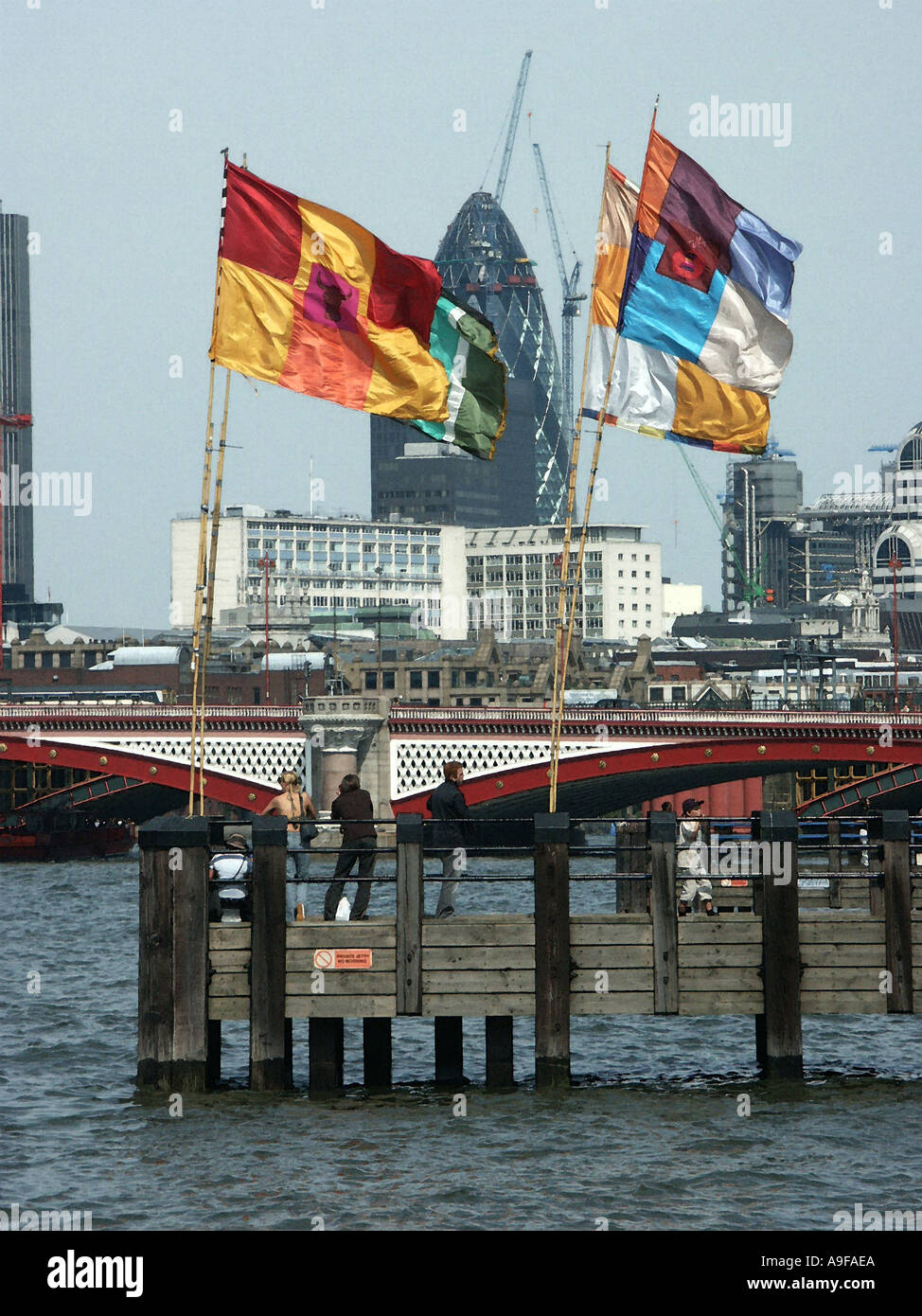 Swiss Re Bâtiment vu de l'autre côté de la Tamise à travers les drapeaux sur une jetée de South Bank London Banque D'Images