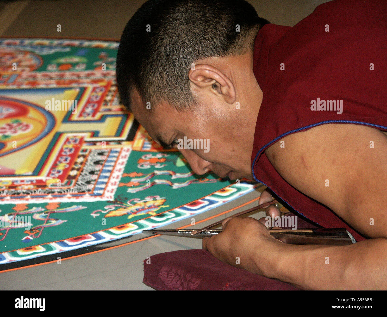 Le moine bouddhiste travaillant sur une paix de peinture sur sable mandala créé à la V A Museum London Juin 2003 Banque D'Images