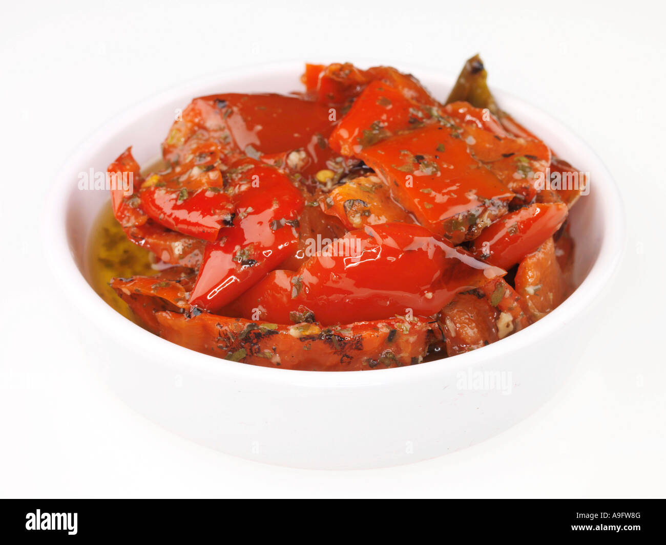 Poivrons rouges grillés servis dans un bol isolé sur un fond blanc avec aucun peuple et un chemin de détourage Banque D'Images