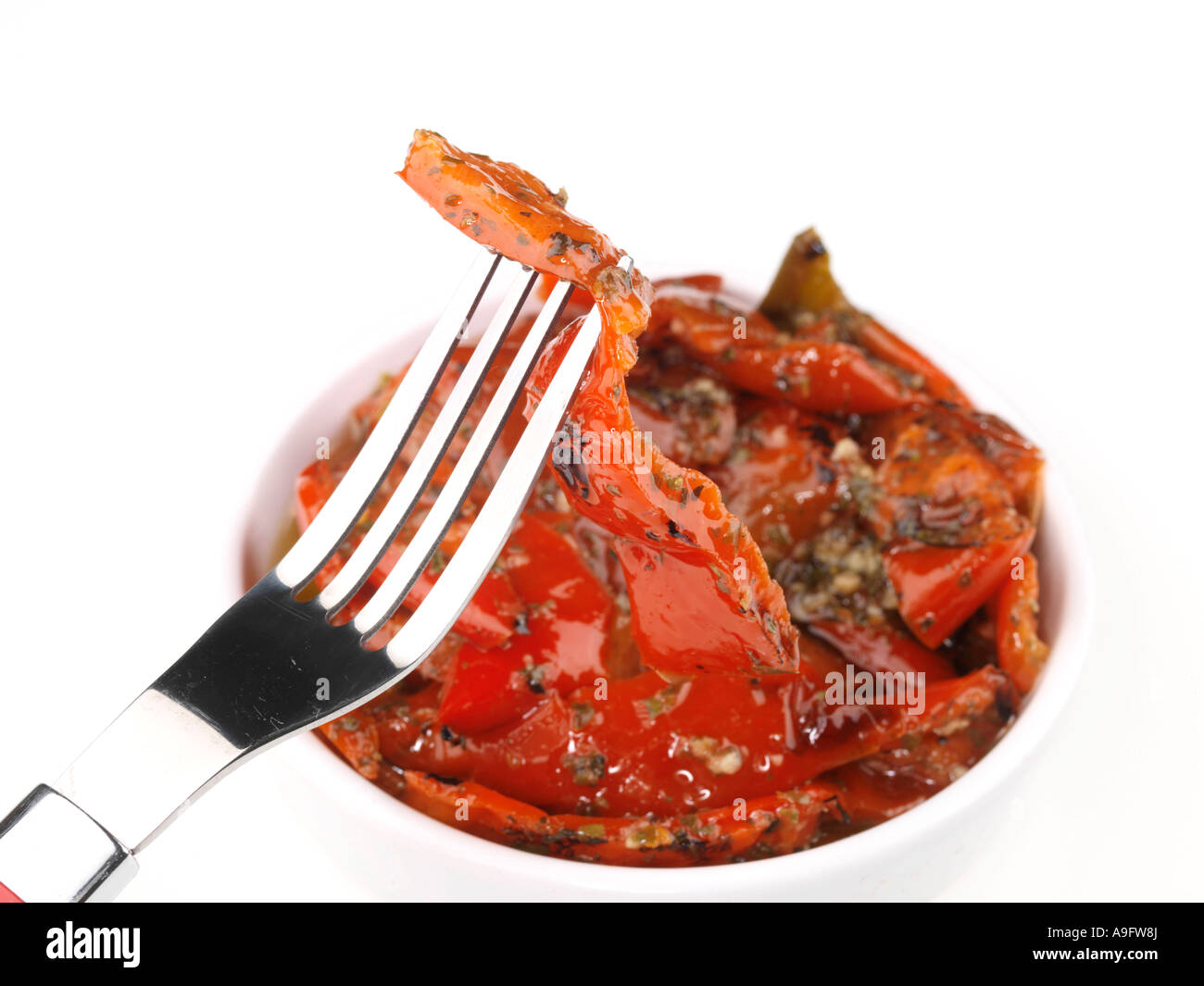 Poivrons rouges grillés servis dans un bol isolé sur un fond blanc avec aucun peuple et un chemin de détourage Banque D'Images