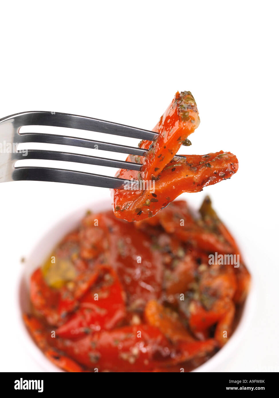 Poivrons rouges grillés servis dans un bol isolé sur un fond blanc avec aucun peuple et un chemin de détourage Banque D'Images