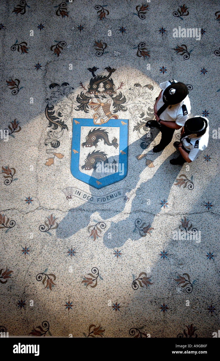 Deux agents de police à pied sur la mosaïque des armoiries cimier à Brighton town hall Banque D'Images