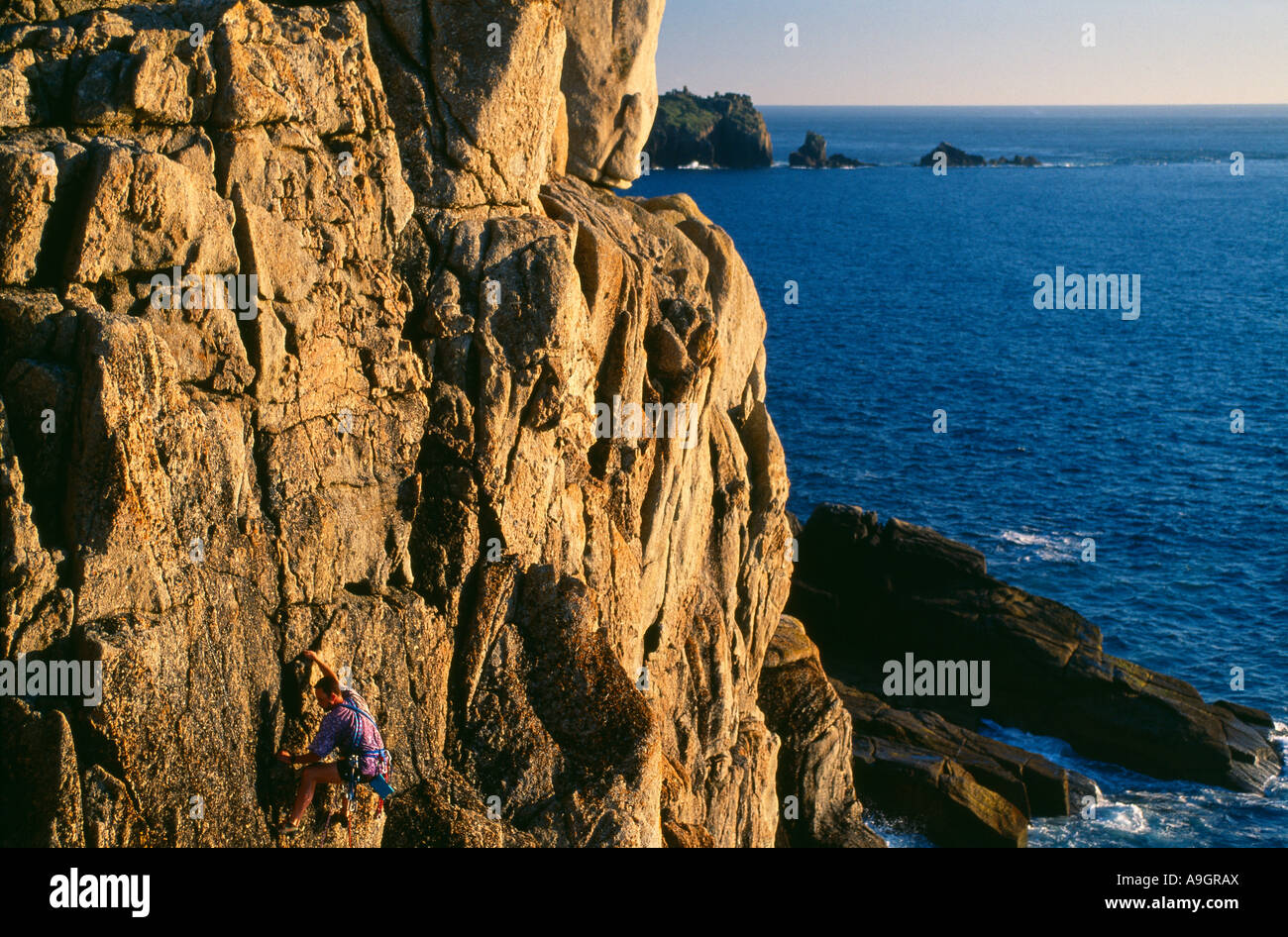 Un alpiniste parution modèle sur les falaises à Sennen Cove Cornwall England UK Banque D'Images