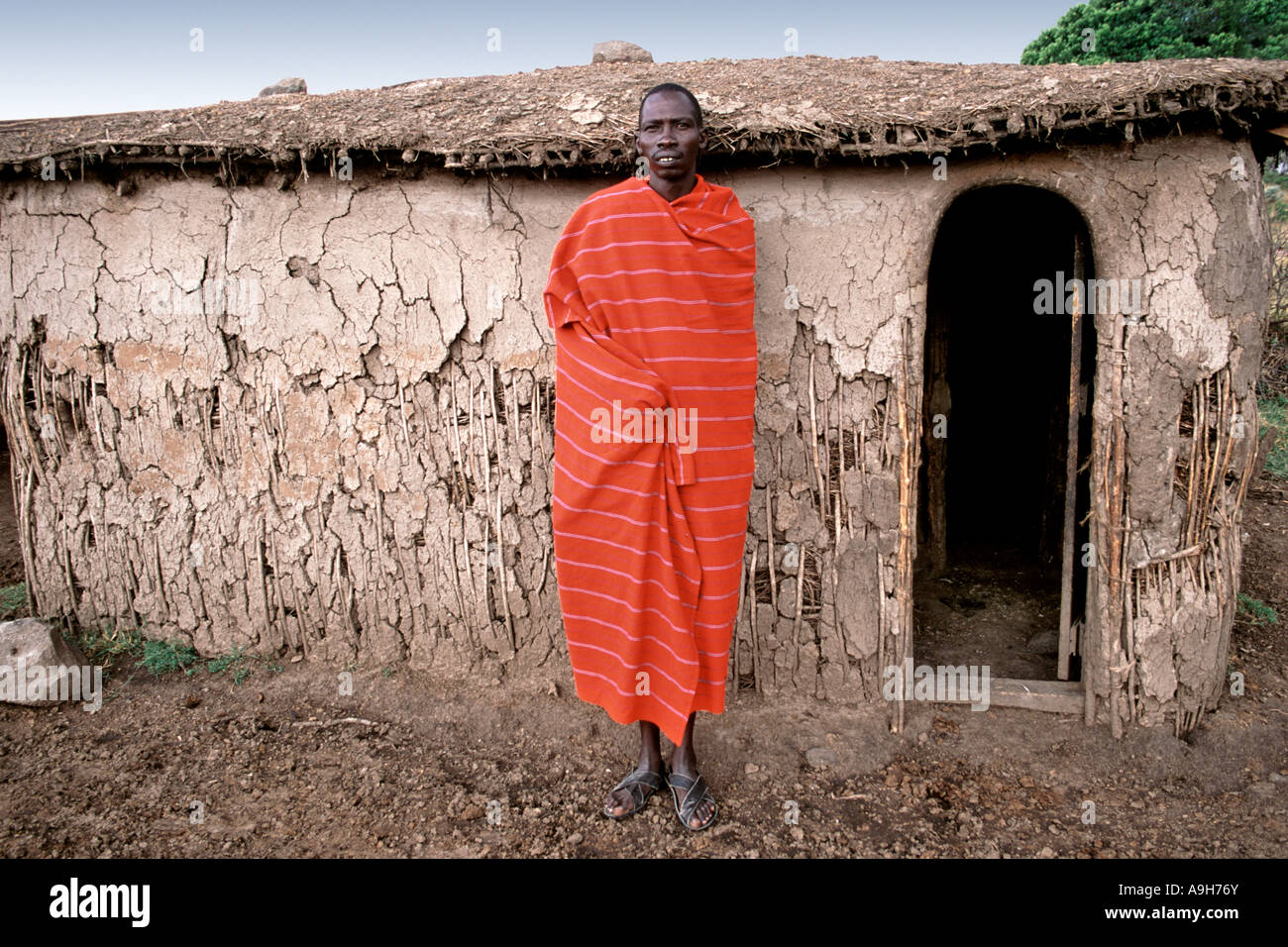 Portrait d'un homme à l'extérieur de sa hutte Masaï dans son village (appelé manyatta) dans le Masai Mara au Kenya. Banque D'Images