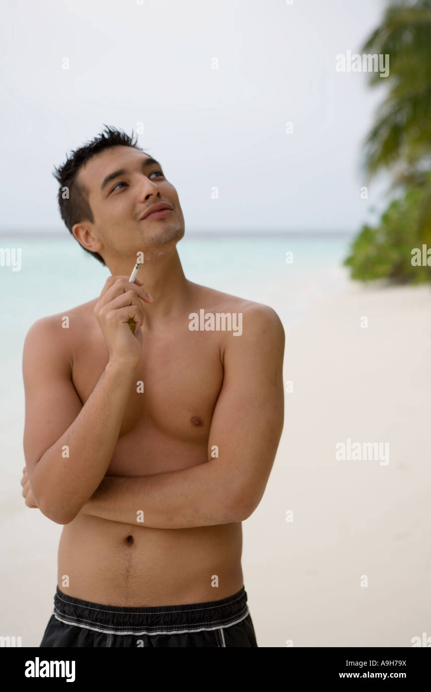 Un portrait d'une jeune homme qui fume sur un Maldavian beach Banque D'Images