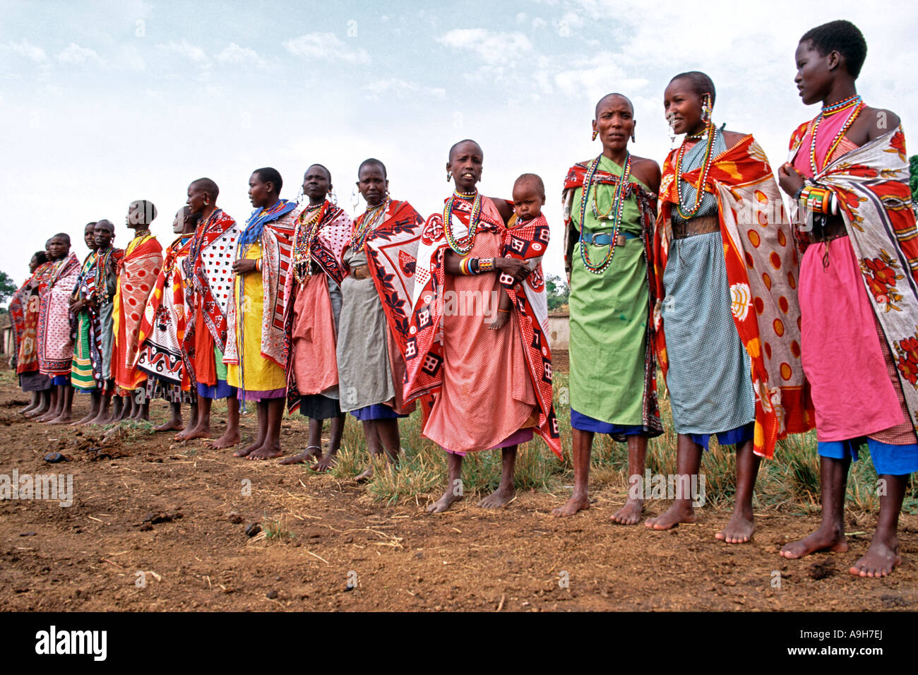 Les femmes masaï effectuer un traditionel Bienvenue aux touristes se rendant sur leur village manyatta dans le Masai Mara au Kenya. Banque D'Images