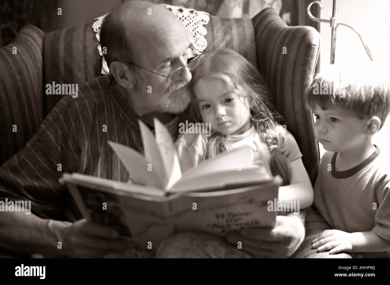 ROCK HILL EN CAROLINE DU SUD livre lecture grand-père à ses petits-enfants sépia Noir et blanc Photographies également disponible en Banque D'Images