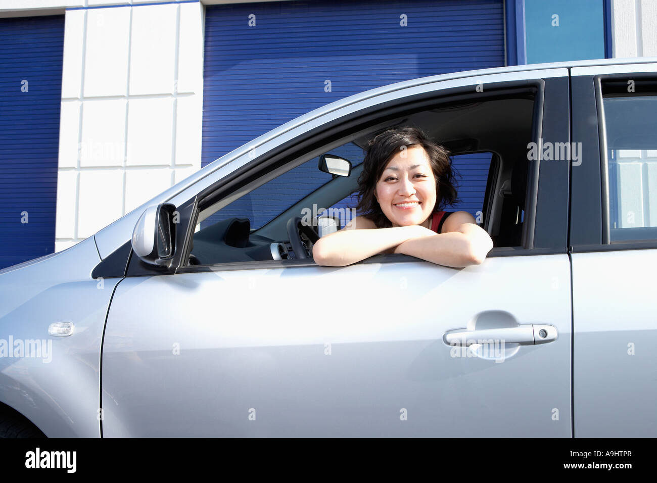 Portrait of Asian woman leaning out car window Banque D'Images