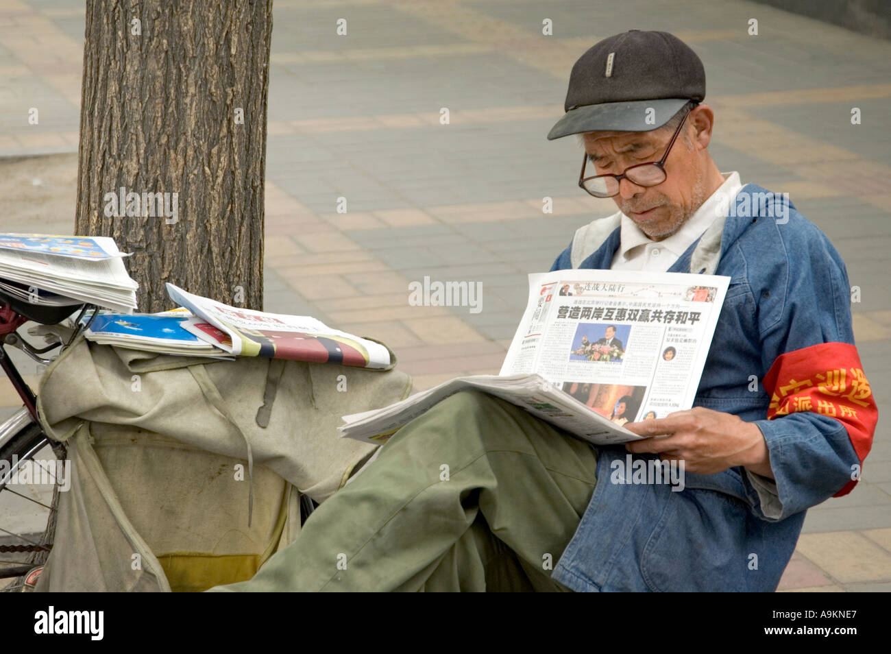 Lecture du vendeur de journaux quotidiens à l'STREET DONGCHENG BEIJING CHINE Banque D'Images