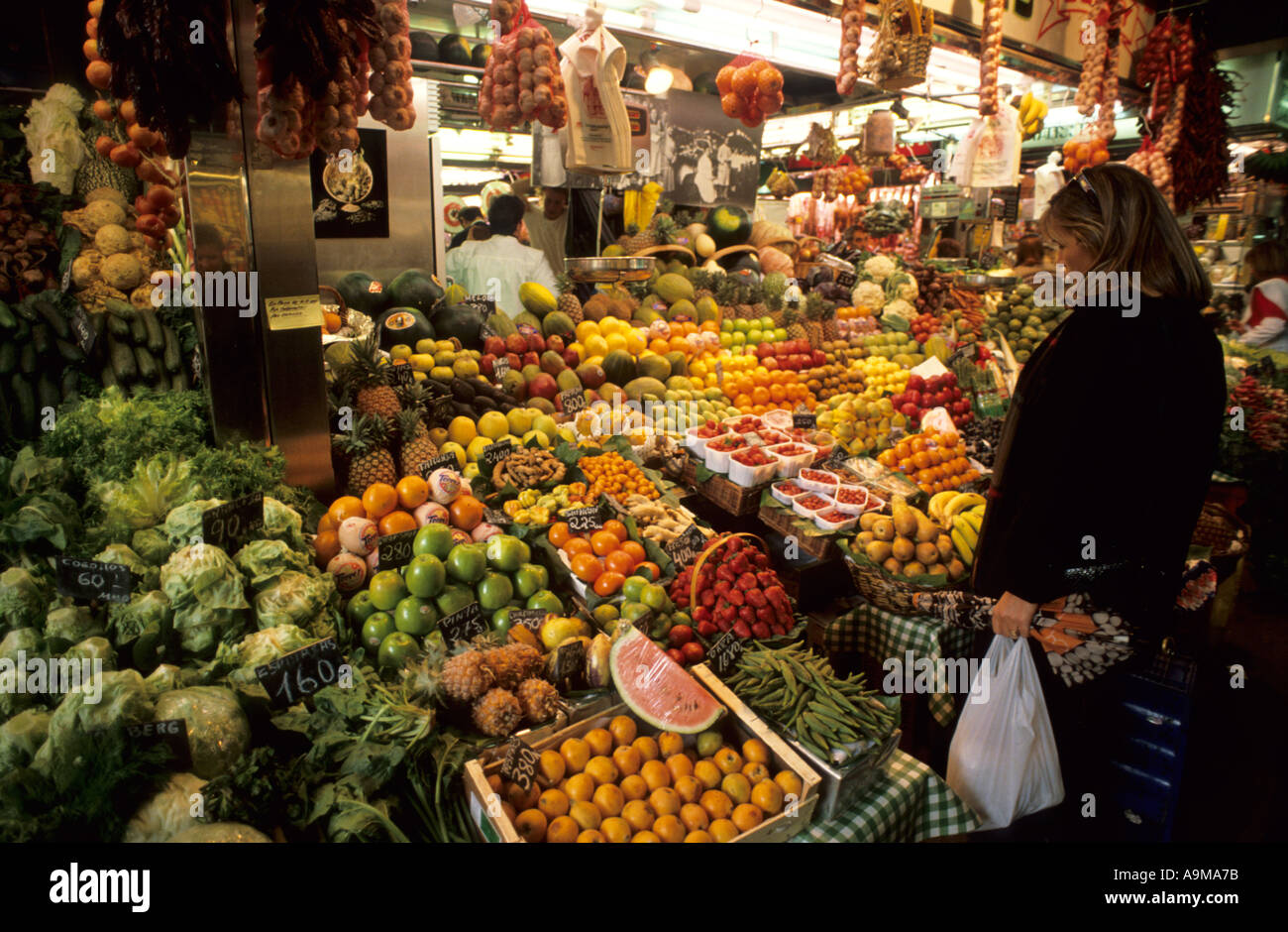 Jeune femme sur un fruit un kiosque de légumes couverts mercat St Josep La Boqueria Ramblas vieille ville Barcelona La Catalogne Espagne Banque D'Images