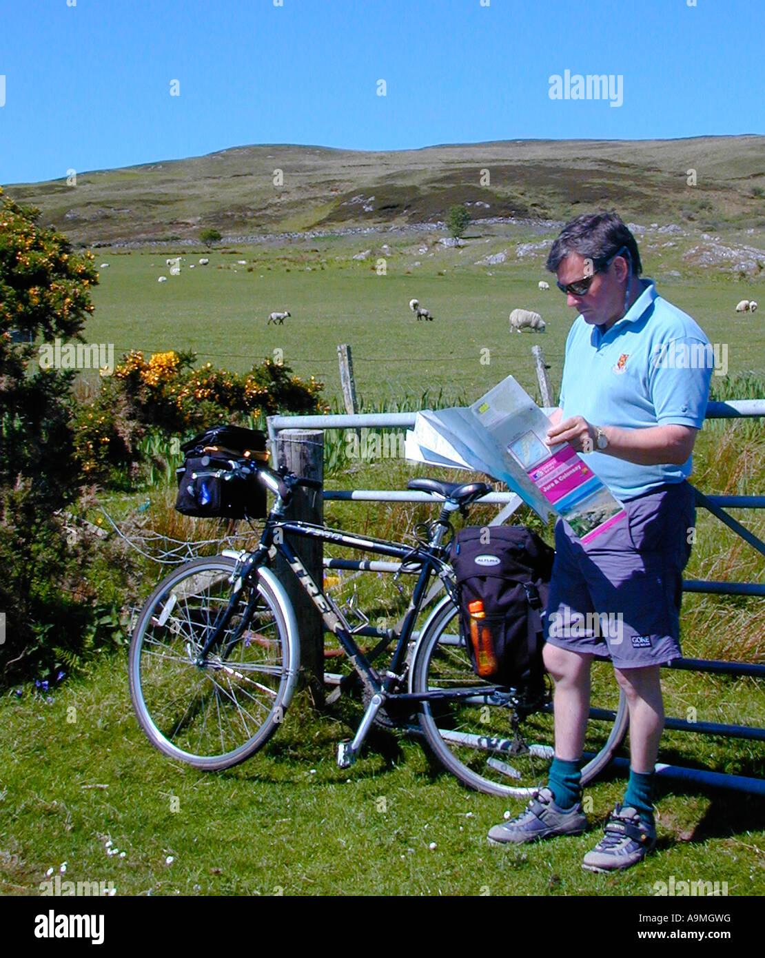 Cycliste homme vérifie son Ordnance Survey map lors d'une balade en vélo sur l'île de Colonsay Hébrides intérieures de l'Écosse Banque D'Images