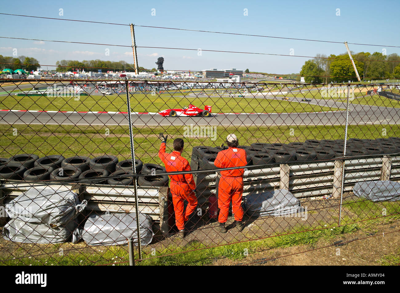 Derrière la barrière de sécurité marshalls crash au circuit de course automobile Banque D'Images