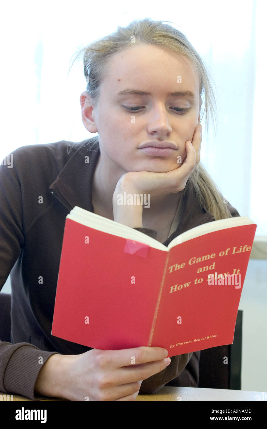 Teenage girl reading self help book Banque D'Images