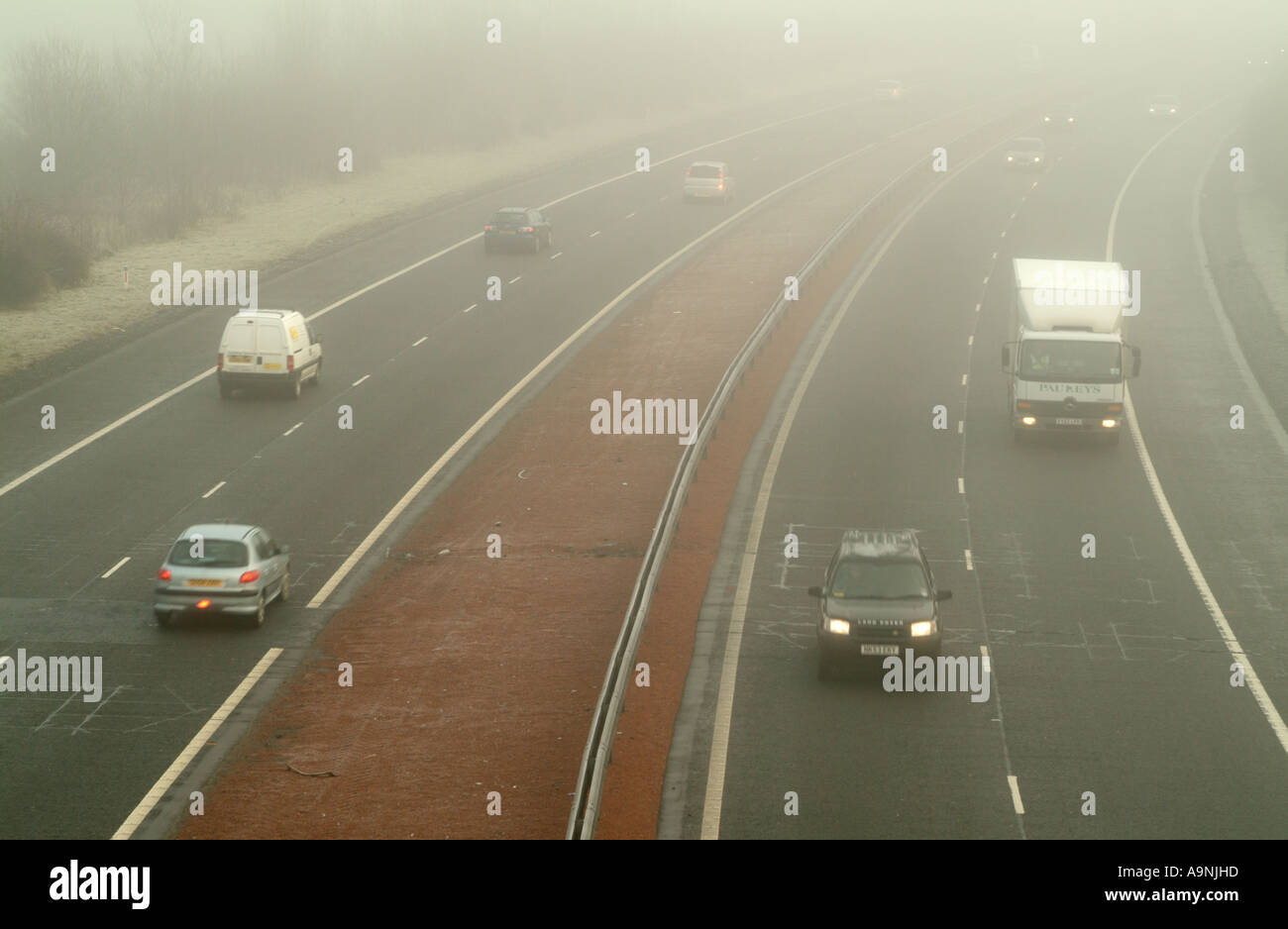 Le trafic important de la conduite dans le brouillard sur l'autoroute M8 près de Ratho, Édimbourg, Écosse, Royaume-Uni. Banque D'Images