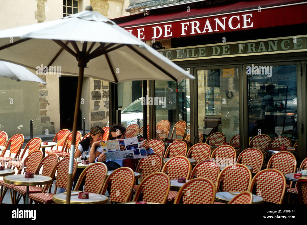 France Paris un couple de lire la carte d'une rue à un café vide Banque D'Images