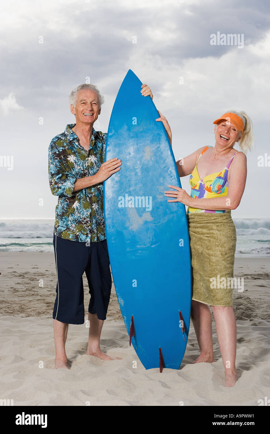 Senior couple holding a surfboard Banque D'Images