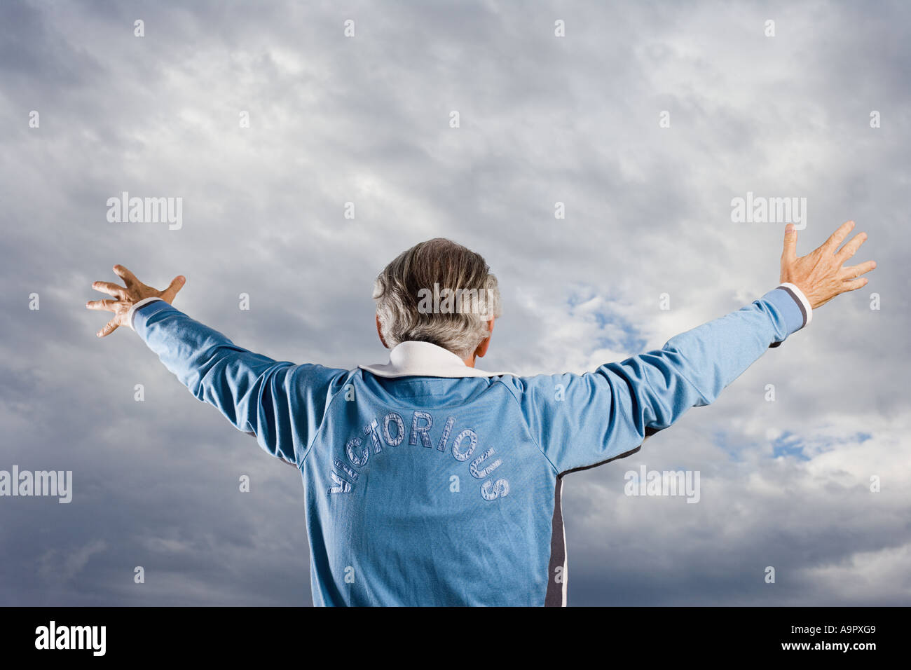 Senior homme avec les bras levés vers le ciel Banque D'Images