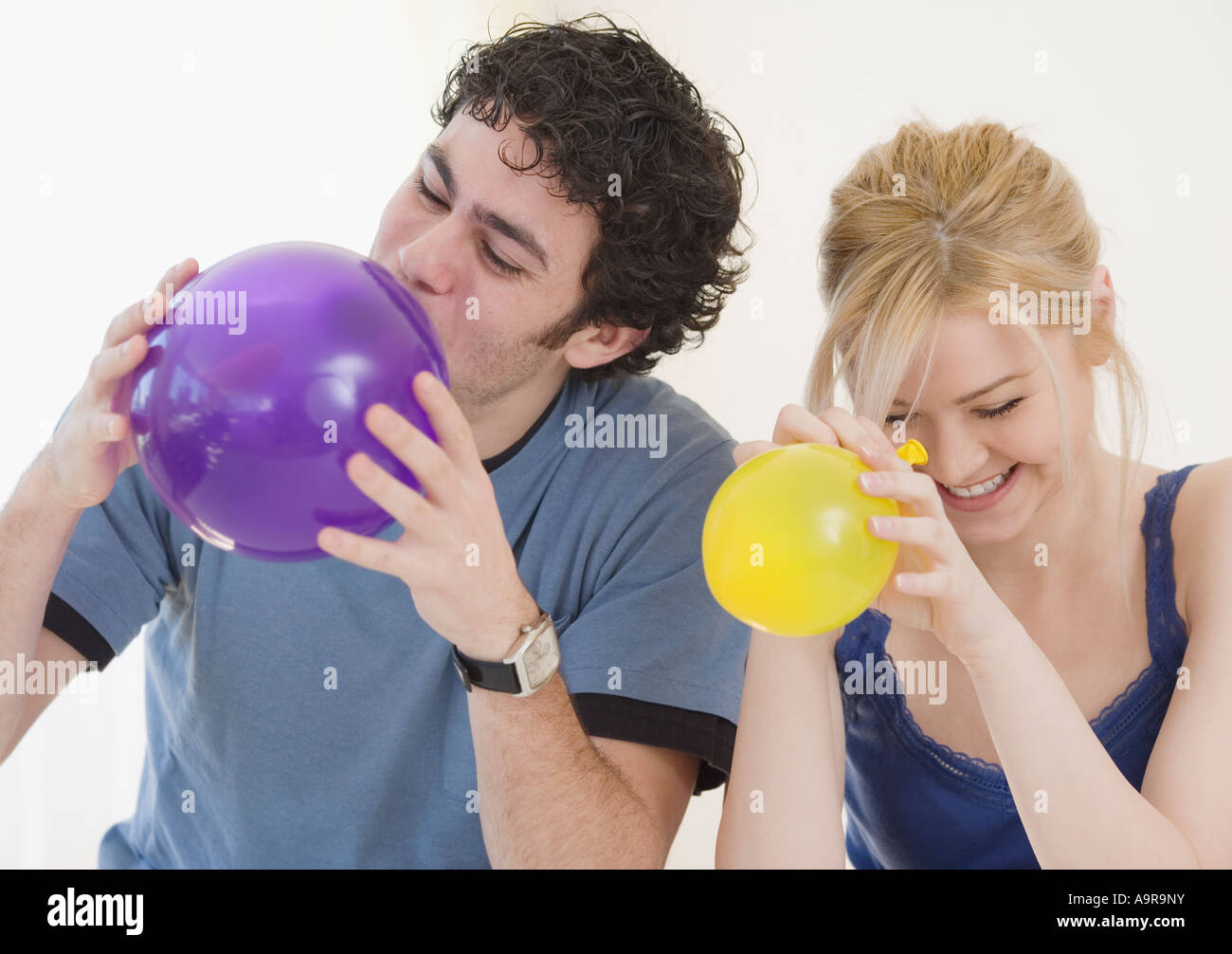 Couple Blowing up balloons Banque D'Images