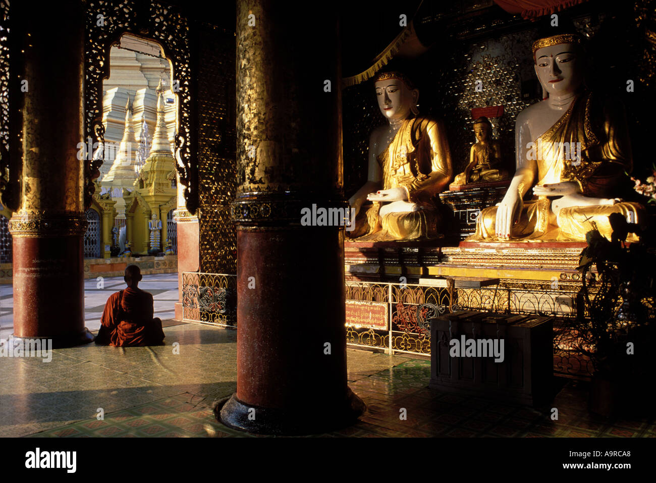 Deux pagodes birmanes pice un moine est assis en méditation dans l'une des nombreuses chapelles entourant la pagode Shwedagon Banque D'Images