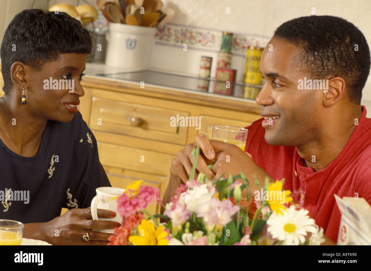 Les jeunes afro-américains couple in kitchen conversations au café du matin matin Banque D'Images