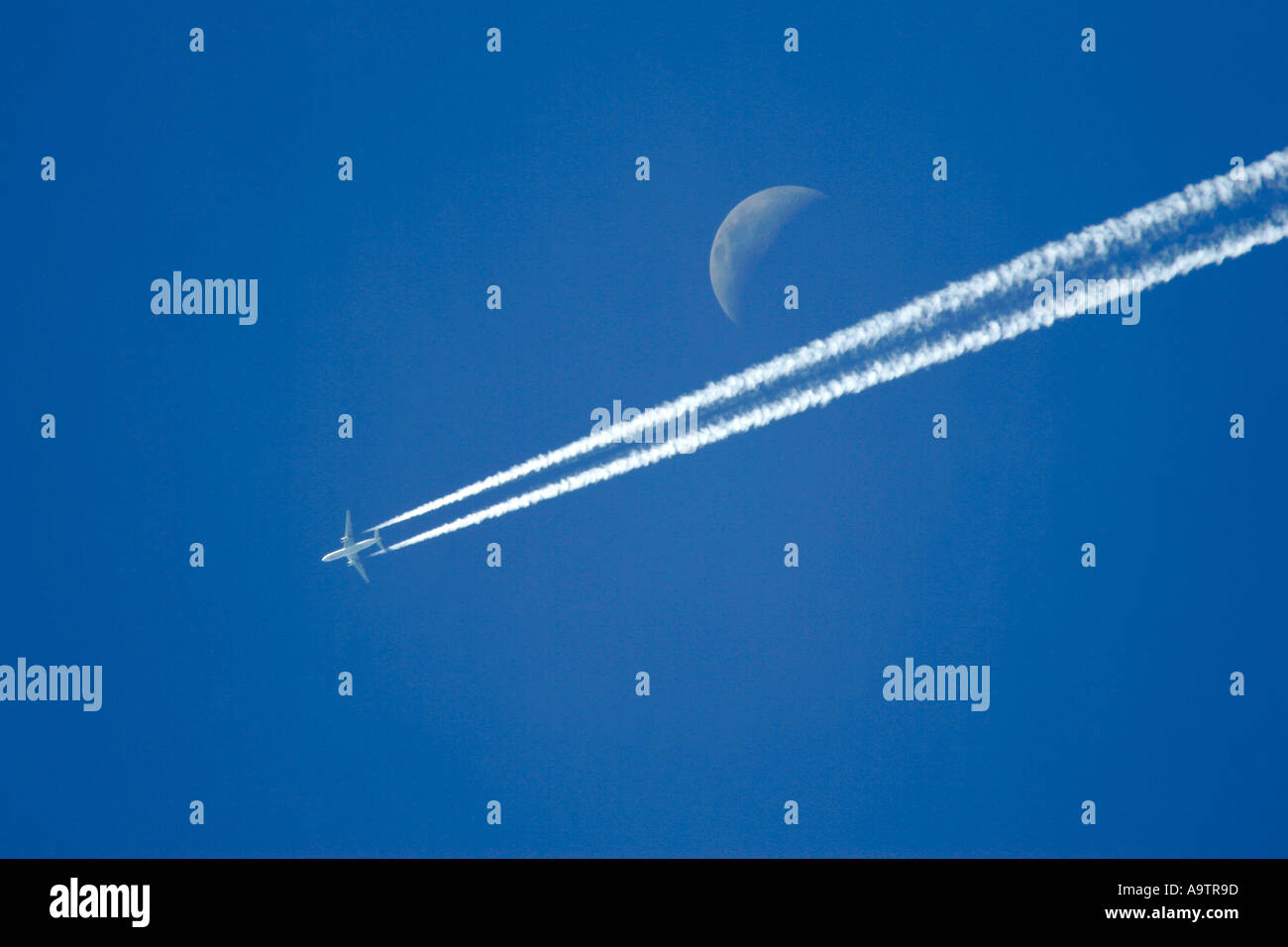 Deux avions de transport de passagers civils bimoteurs de traînées de feuilles sur un ciel bleu avec lune montrant Banque D'Images