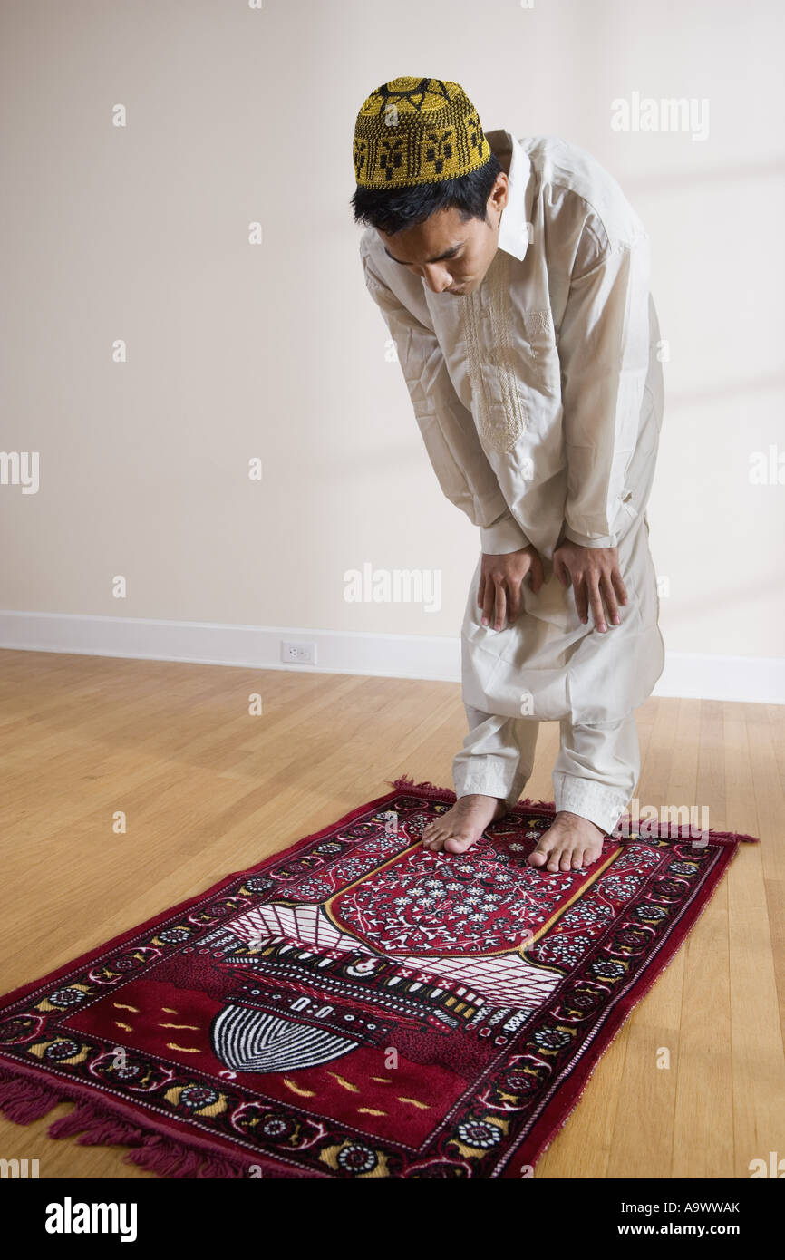 Un musulman de prier sur un tapis de prière Banque D'Images