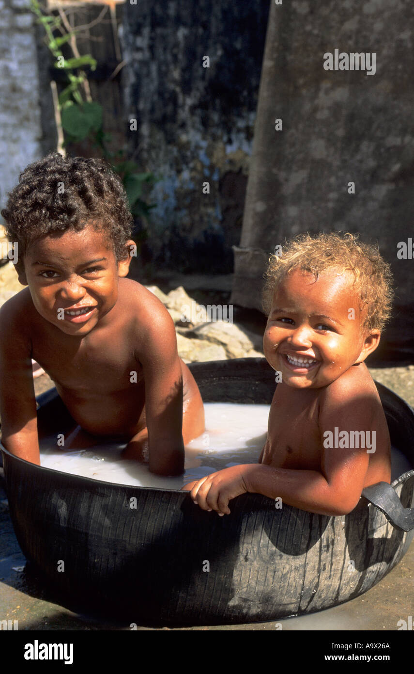 Bahia, Brésil. Deux garçons souriants se baigner dans l'eau savonneuse  sombre dans un tube intérieur d'un pneu Photo Stock - Alamy