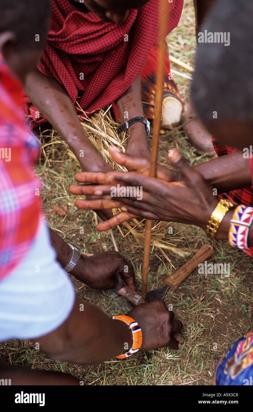 Lolgorian, au Kenya. Moran Maasai Siria (Jeunes guerriers) faire feu à l'aide de la méthode de friction en bois traditionnel. Banque D'Images