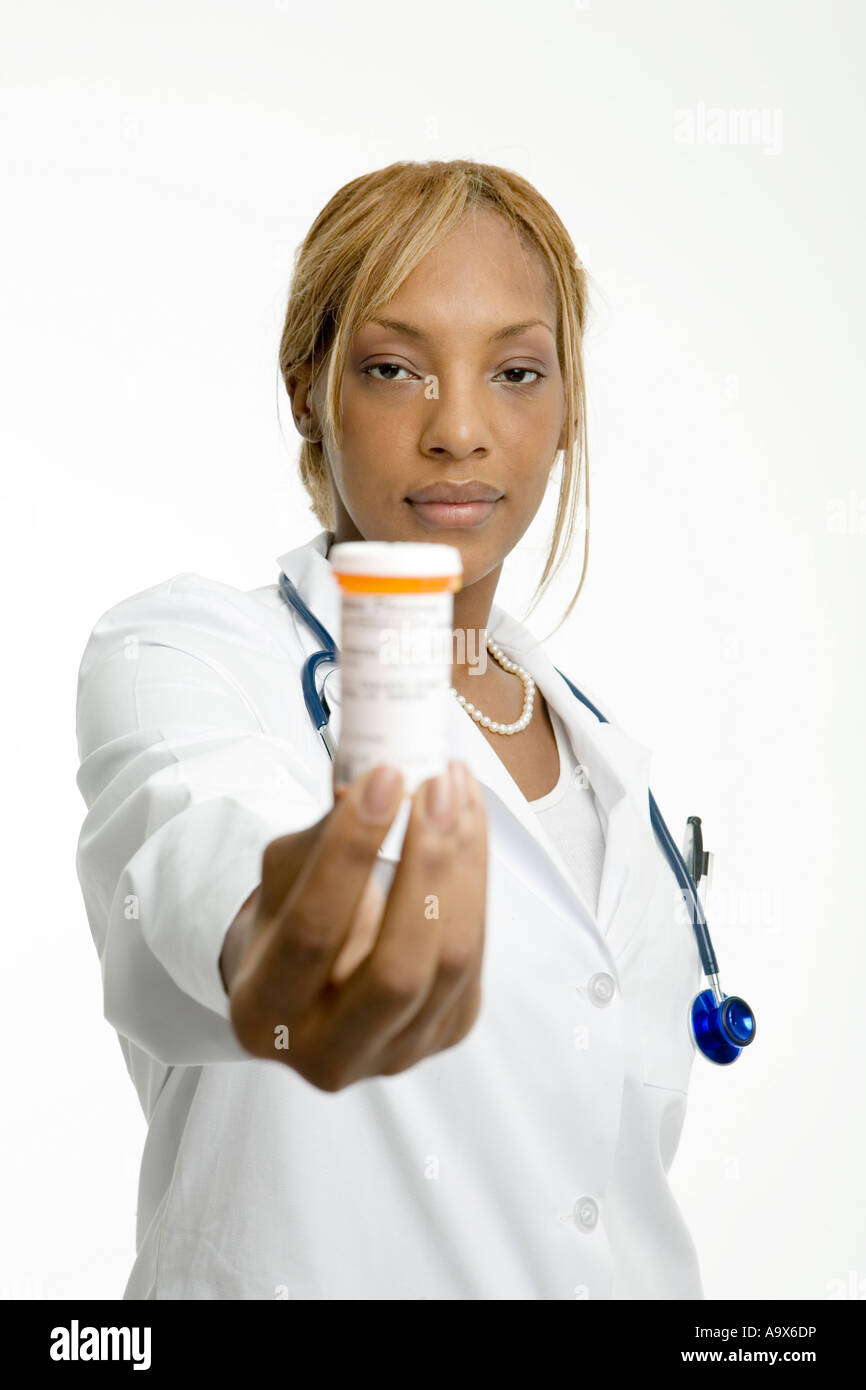 Jeune médecin tenant un pot de prescription pills vers l'appareil photo, son visage est à la Banque D'Images