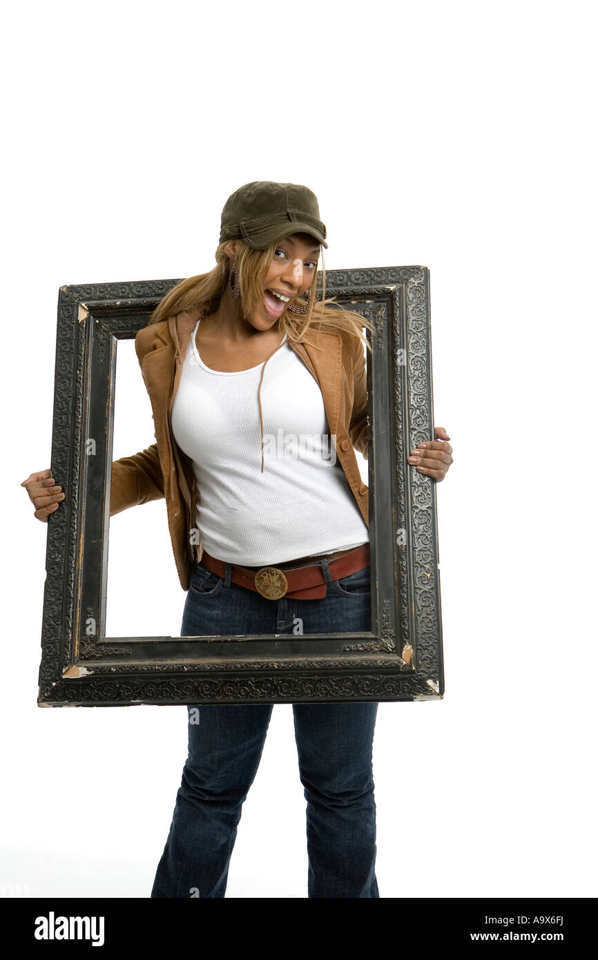 Pretty young woman happily posant avec un cadre photo Banque D'Images