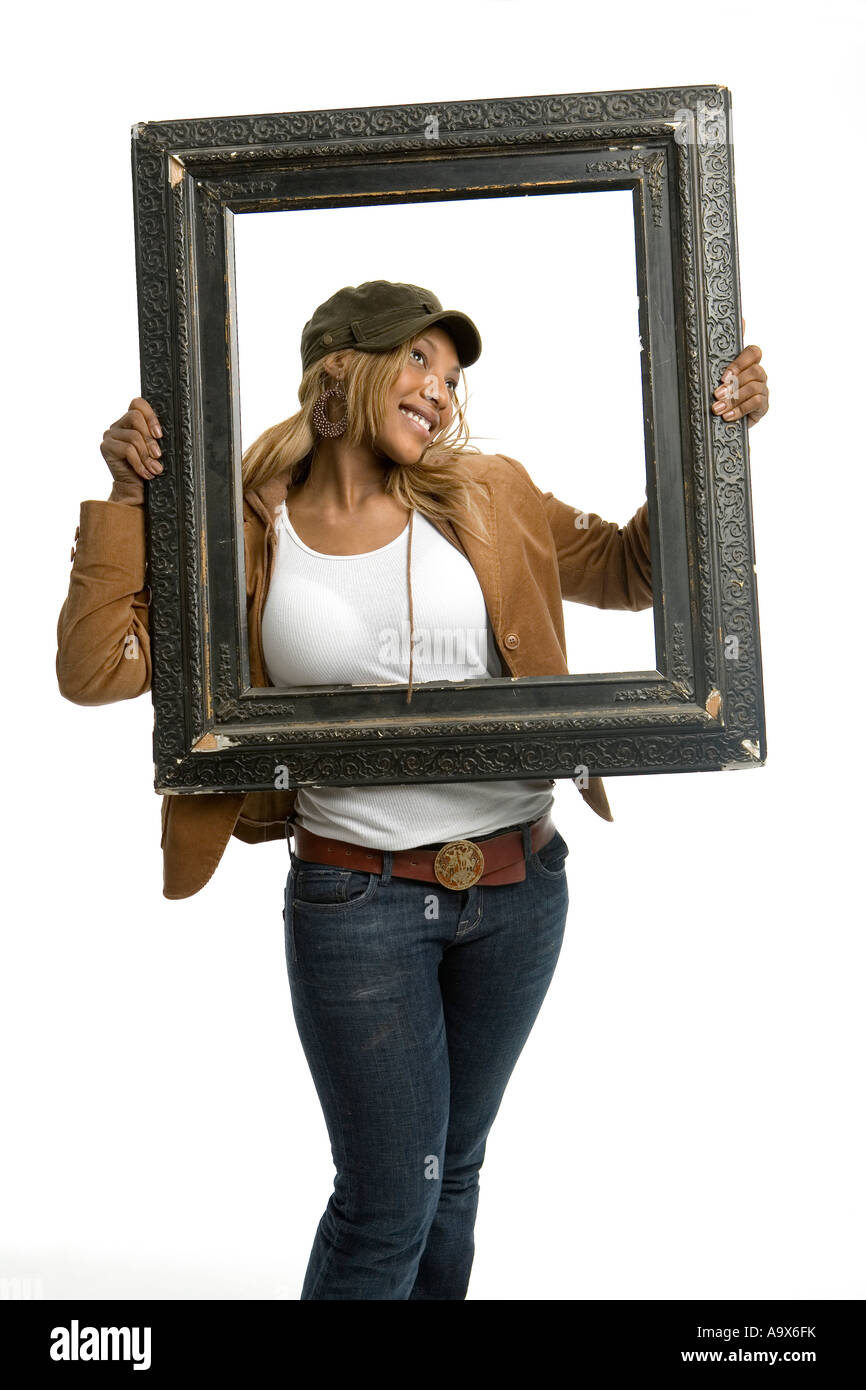 Belle jeune femme noire de déconner et posant avec un cadre photo Banque D'Images